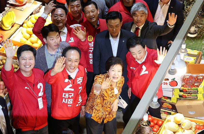 박근혜 전 대통령이 23일 오후 대구 북구 칠성시장을 찾아 추경호 국민의힘 대구시장 후보 등 일행과 함께 이동하며 손을 흔들고 있다. 2026.5.23 ⓒ 뉴스1 공정식 기자