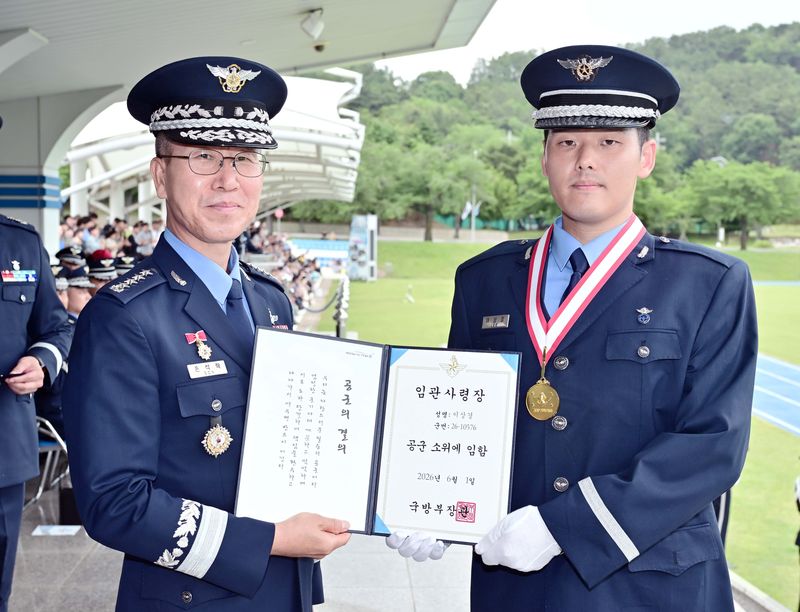 공군은 26일 공군교육사령부 대연병장에서 손석락 공군참모총장 주관으로 제156기 학사사관후보생 임관식을 거행했다. 국방부장관 수상자 이상경 소위가 손 총장으로부터 임관사령장을 수여받고 있다. 공군 제공