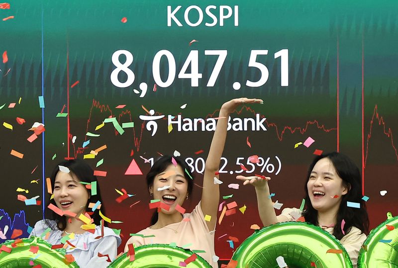 코스피 지수가 종가 기준 최초로 8,000대를 기록한 26일 오후 서울 중구 하나은행 본점 딜링룸에서 직원들이 축하 세레머니를 하고 있다. 뉴스1 제공