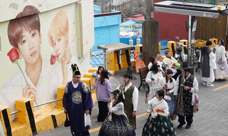 지난 3월 부산 사하구 감천문화마을에서 외국인 관광객들이 BTS 멤버 정국·지민이 그려진 대형 벽화를 배경으로 기념촬영을 하고 있다. 뉴스1
