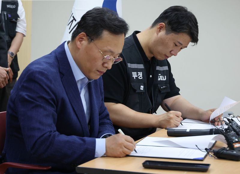 [수원=뉴시스] 김종택기자 = 여명구 삼성전자 DS(디바이스솔루션·반도체 사업 담당) 피플팀장(왼쪽)과 최승호 삼성그룹 초기업노동조합 삼성전자지부 위원장이 지난 20일 오후 경기 수원시 장안구 경기지방고용노동청에서 열린 삼성전자 노사교섭 결과 브리핑에서 합의안에 서명을 하고 있다. (공동취재) 2026.05.20. photo@newsis.com