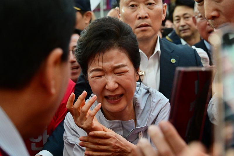 [진주=뉴시스] 차용현 기자 = 사전투표일을 이틀 남겨둔 27일 오전 경남 진주시 중앙시장을 찾은 박근혜 전 대통령이 시민들과 악수를 한 후 고통스러운 표정을 짓고 있다. 2026.05.27. con@newsis.com