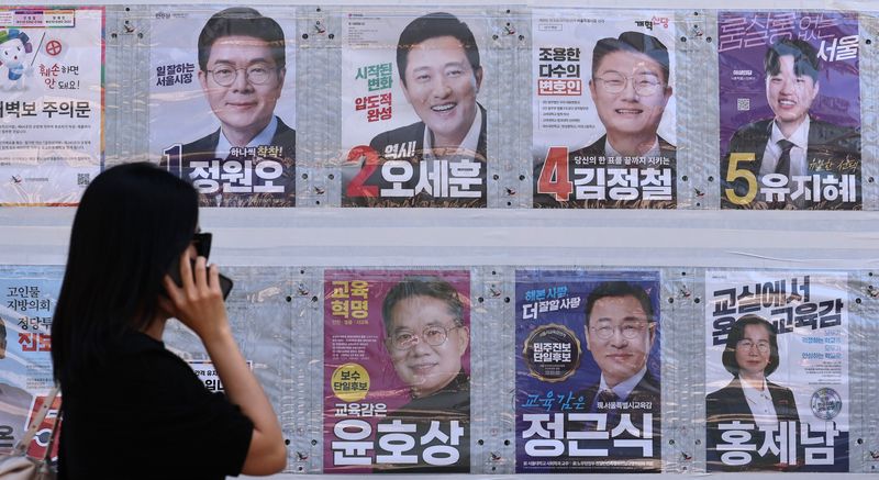 제9회 전국동시지방선거일을 사흘 앞둔 31일 한 시민이 서울 중구 명동 일대에 붙은 선거벽보를 살피고 있다. 2026.5.31 ⓒ 뉴스1 구윤성 기자