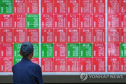 한 도쿄 시민이 15일 증시 시황판을 뚫어지게 쳐다보고 있다. 연합뉴스