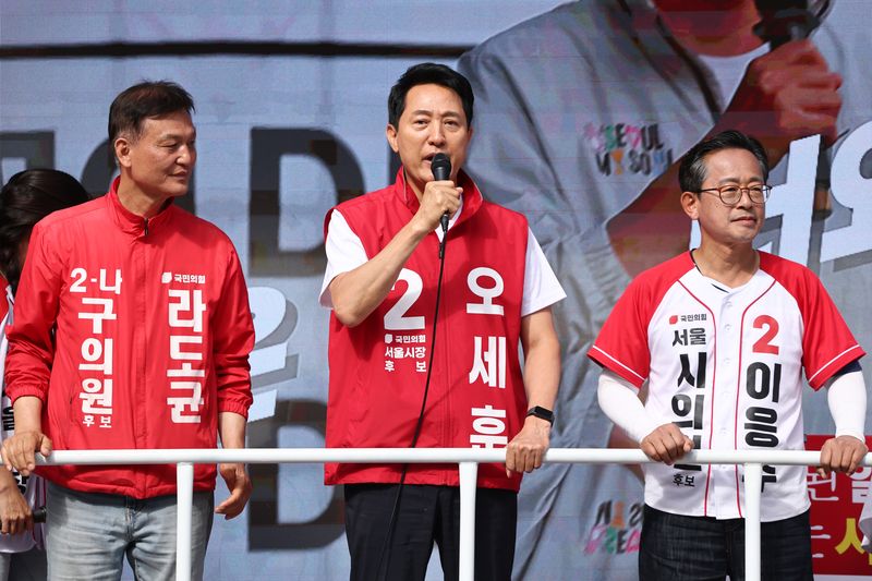 국민의힘 오세훈 서울시장 후보(가운데)가 1일 서울 광화문역 인근에서 출근 인사를 하고 있다. 연합뉴스