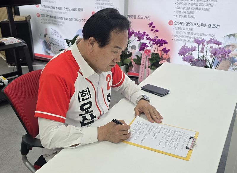 자필편지를 쓰고 있는 이권재 국민의힘 오산시장 후보. 선거사무소 제공
