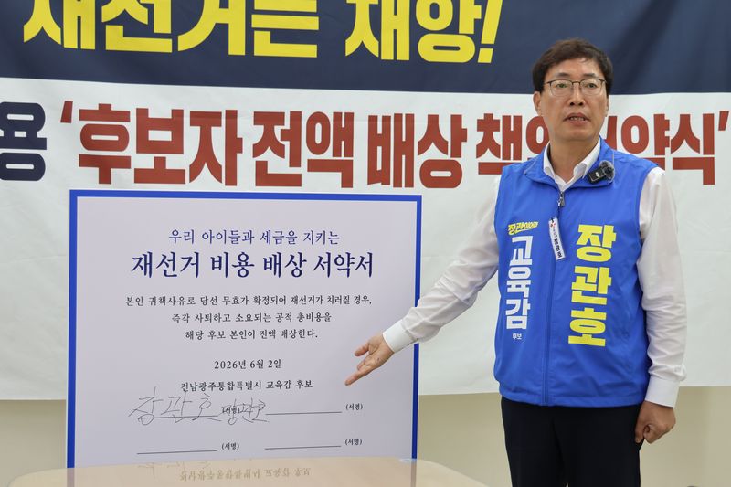 장관호 전남광주통합특별시교육감 후보가 2일 광주광역시교육청 브리핑룸에서 기자회견을 열고 '아이들의 미래와 세금을 지키기 위한 재선거 비용 배상 책임 서약서'에 단독 서명한 뒤 사진 촬영을 하고 있다. 후보 측 제공