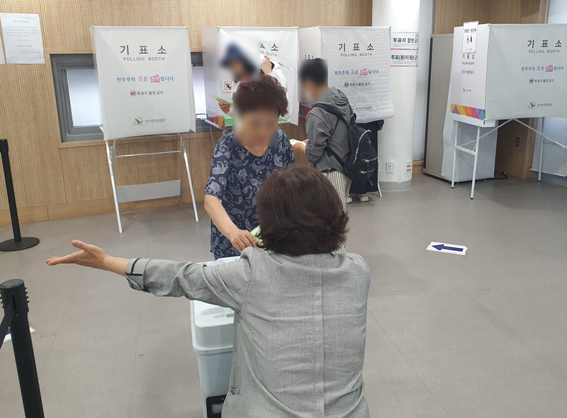 상도동 투표소에서 선거 사무원이 투표를 마친 주민에게 다음 절차를 안내하고 있다. 사진=최승한 기자