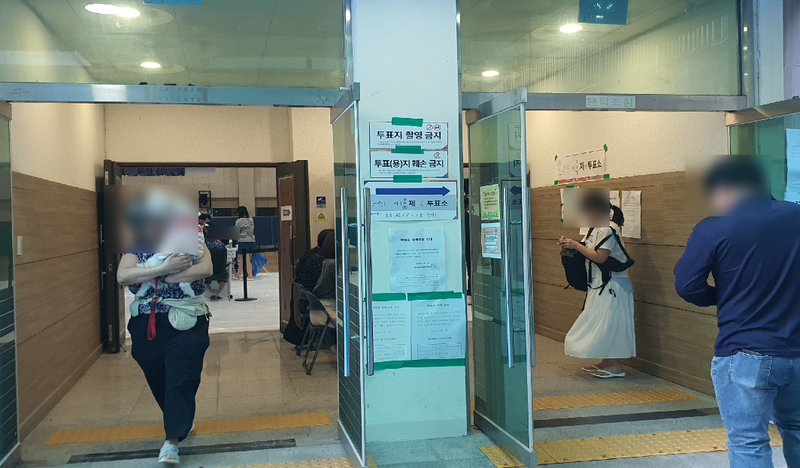서울 동작구 본동초등학교에 마련된 노량진제1동 제6투표소 앞에서 한 주민이 반려견을 안고 투표소를 나서고 있다. 사진=최승한 기자