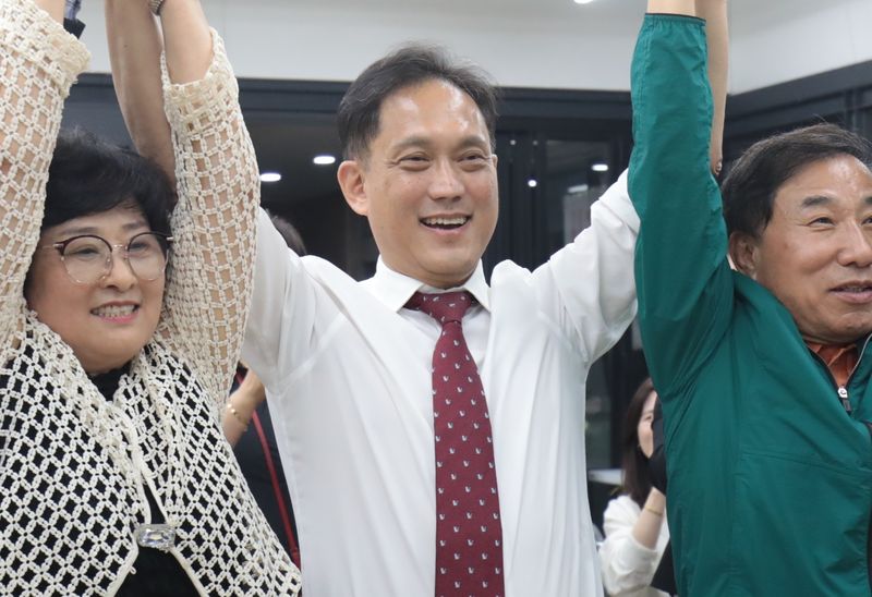 김태규 울산 남구갑 국회의원 보궐선거 국민의힘 후보가 4일 울산 남구 소재 자신의 선거캠프에서 당선이 확실시 되자 지지자들과 손을 맞잡고 환호하고 있다. 뉴스1