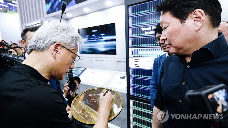 협력 제품 전시물에 사인 남기는 젠슨 황 엔비디아 CEO (출처=연합뉴스)