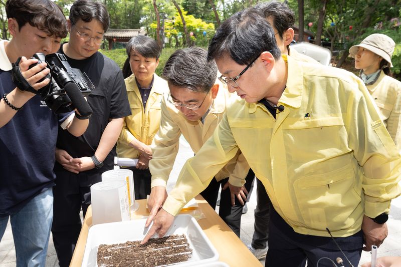 [서울=뉴시스] 조수정 기자 = 김성환 기후에너지환경부 장관이 25일 서울 노원구 불암산을 찾아 붉은등우단털파리(러브버그) 방제 현장을 찾아 유충 서식 상태와 성충 포집 장비를 살피고 친환경 방제약품을 이용한 방제 작업에 참여하고 있다. (사진=기후에너지환경부 제공) 2026.05.25. photo@newsis.com *재판매 및 DB 금지