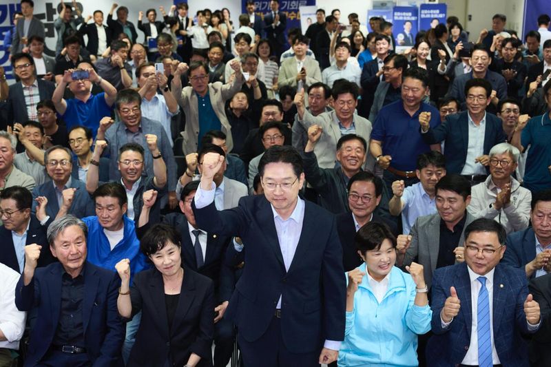 [창원=뉴시스]더불어민주당 김경수 경남도지사 후보가 4일 오후 6시 창원 선거사무소에서 방송3사 출구조사를 시청하던 중 당선 예측으로 나오자 일어나 지지자들에게 인사하고 있다.(사진=김경수 후보 캠프 제공)2026.06.03. photo@newsis.com