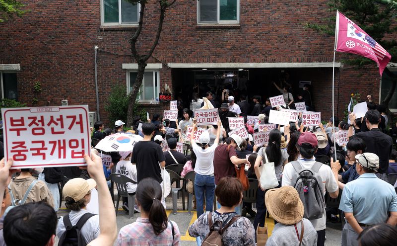 [서울=뉴시스] 홍효식 기자 = 4일 6·3 지방선거 투표용지 부족 사태를 겪은 서울 송파구 잠실7동 제2투표소 앞에서 시민들이 '선거관리위원회 해체, 부정선거, 재선거' 구호를 외치고 있다. 2026.06.04. yesphoto@newsis.com