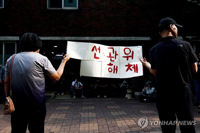 '선관위 해체' 손팻말 든 시민들 (출처=연합뉴스)