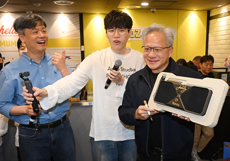 젠슨 황 엔비디아 최고경영자(CEO)가 7일 서울 강남구 옵티멈존 PC카페에서 크래프톤 유저에게 선물할 최신 그래픽카드 '지포스RTX5090'에 사인하고 있다. (공동취재) 2026.6.7 ⓒ 뉴스1 김진환 기자