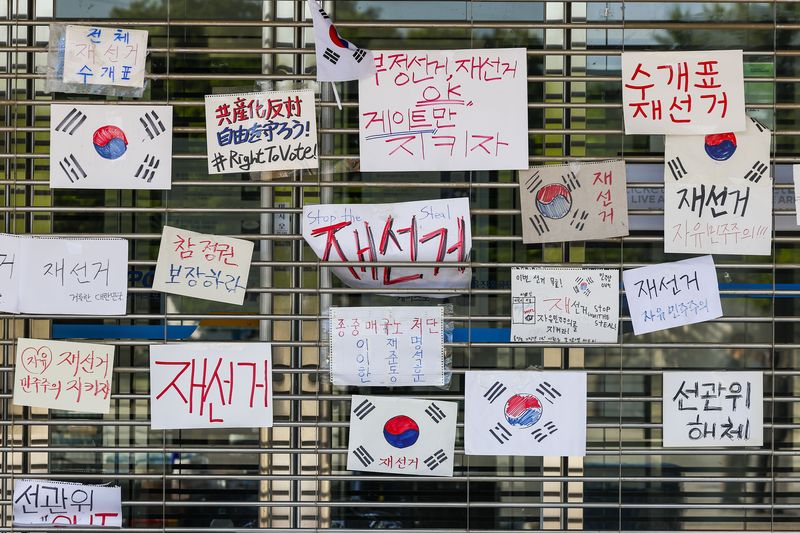 [서울=뉴시스] 정병혁 기자 = 제9회 전국동시지방선거 투표용지 부족 사태에 항의하며 개표소 봉쇄 시위를 이어고 있는 가운데 9일 서울 송파구 올림픽공원 핸드볼경기장에 설치된 개표소 앞에 재선거 촉구 피켓이 붙어 있다. 2026.06.09. jhope@newsis.com