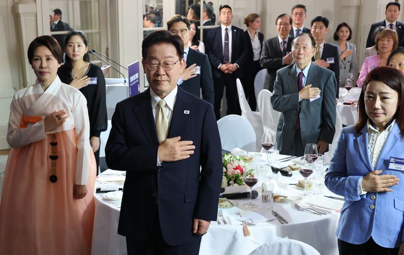 이재명 대통령과 김혜경 여사가 9일(현지시간) 벨기에 브뤼셀 한 호텔에서 열린 동포 만찬간담회에서 국기에 경례하고 있다. 연합뉴스