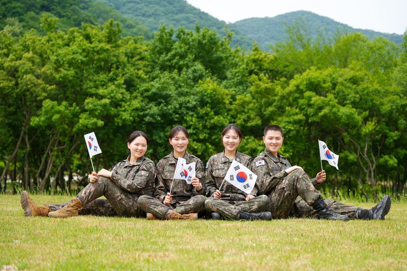 육·해·공군 부사관으로 복무 중인 김문정 중사, 김문소 중사, 김태희 중사, 김준원 하사(왼쪽부터) 4남매가 호국보훈의 달을 맞아 태극기를 들고 기념사진을 촬영하고 있다. 육균 제공