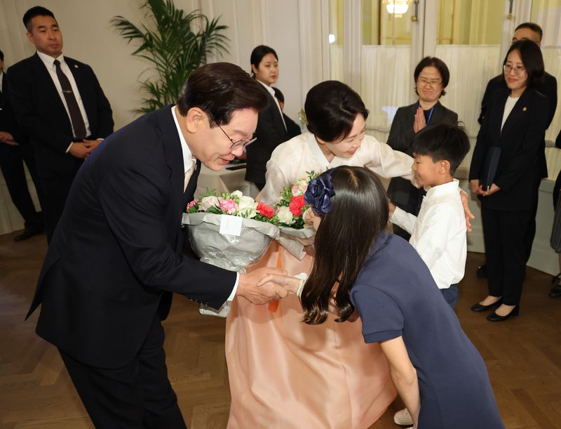 이재명 대통령과 김혜경 여사가 지난 9일(현지시간) 벨기에 브뤼셀 한 호텔에서 열린 동포 만찬간담회에서 화동으로부터 꽃다발을 받고 있다. 연합뉴스