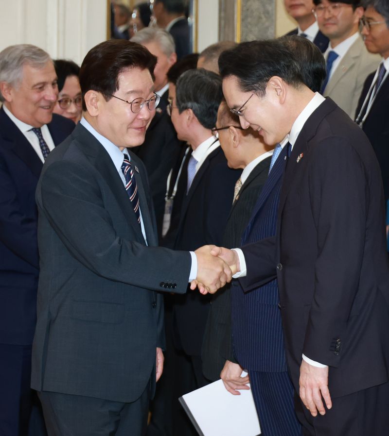 이재명 대통령이 12일(현지시간) 이탈리아 로마의 한 호텔에서 열린 비즈니스 라운드테이블에 입장하며 이재용 삼성전자 회장과 악수하고 있다. 연합뉴스