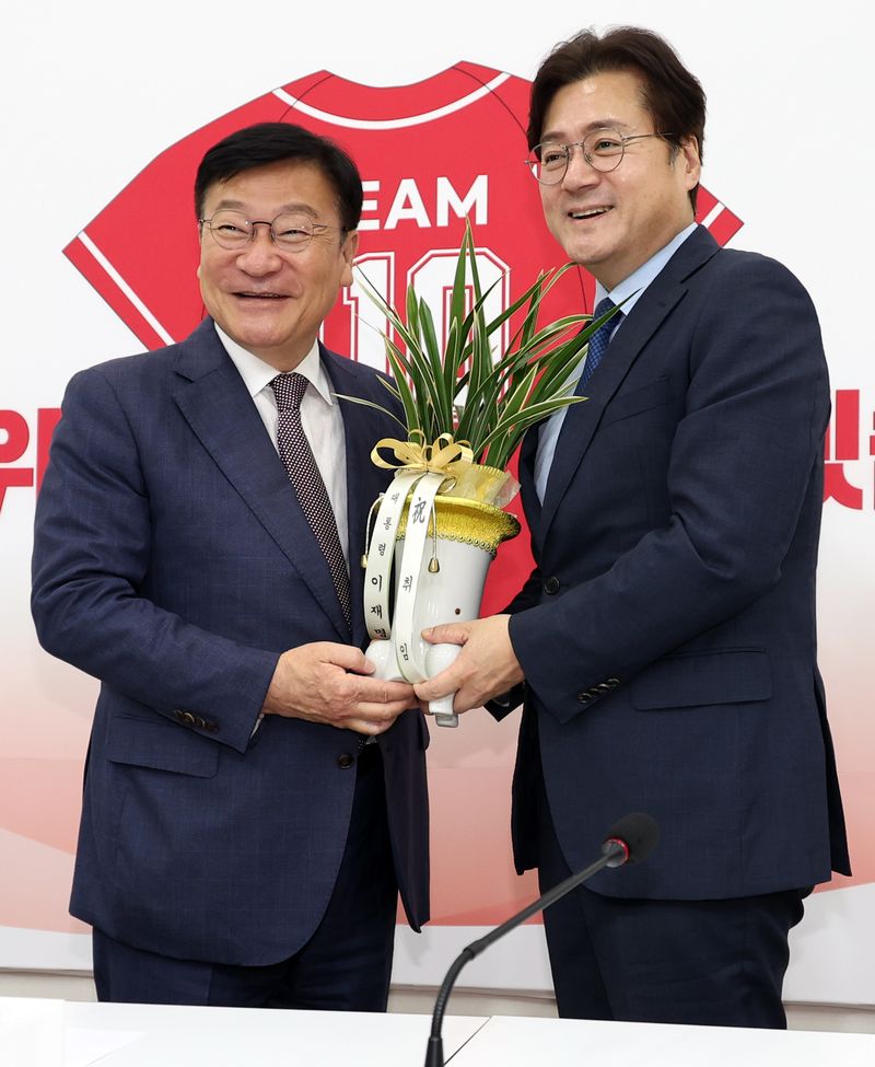 [서울=뉴시스] 최진석 기자 = 정점식(왼쪽) 국민의힘 신임 원내대표가 11일 오후 여의도 국회에서 홍익표 대통령비서실 정무수석으로부터 이재명 대통령이 보낸 축하난을 받고 있다. 2026.06.11. myjs@newsis.com