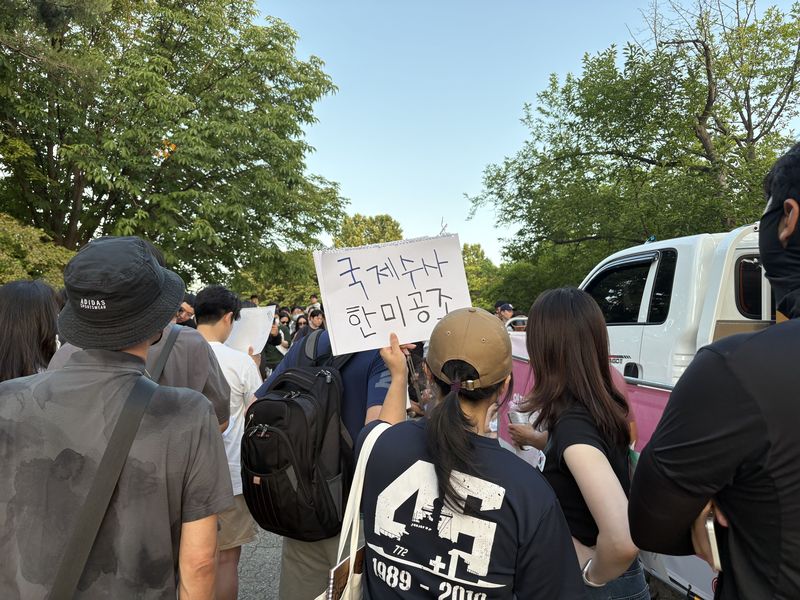 [서울=뉴시스] 신유림 기자 = 13일 오후 서울 송파구 올림픽공원 핸드볼경기장 일대에서 열린 6·3 지방선거 투표용지 부족 사태 규탄 집회에 참가한 한 시민이 '한미공조 국제수사'라고 적힌 손팻말을 들고 이동하고 있다. 2026.06.13. spicy@newsis.com