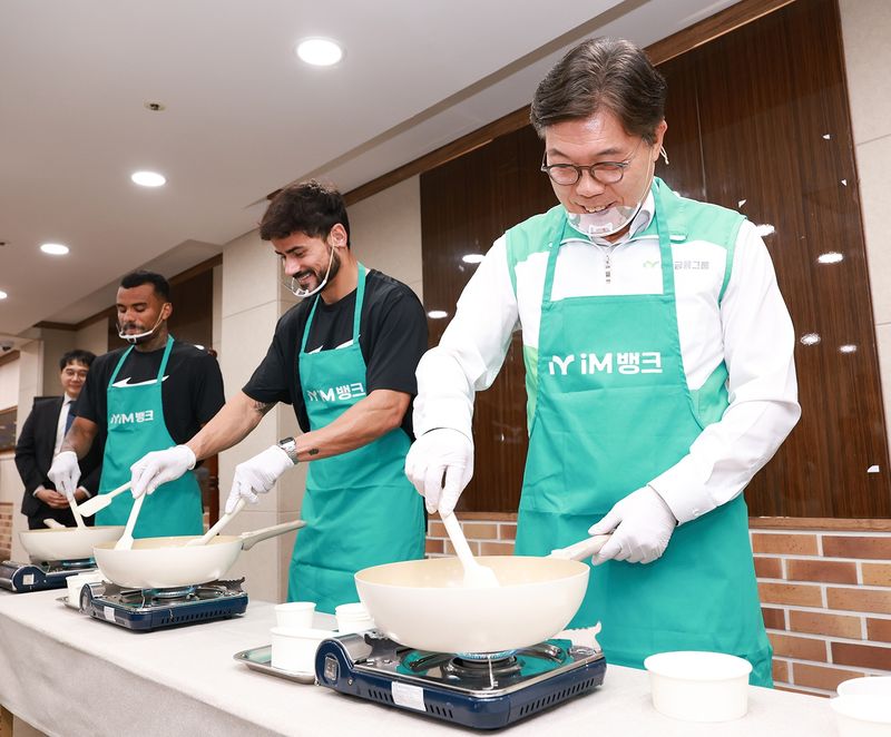황병우 iM금융그룹 회장(오른쪽부터)과 대구FC 세징야 선수, 세라핌 선수가 간식 만들기 봉사활동을 하고 있다. iM금융그룹 제공