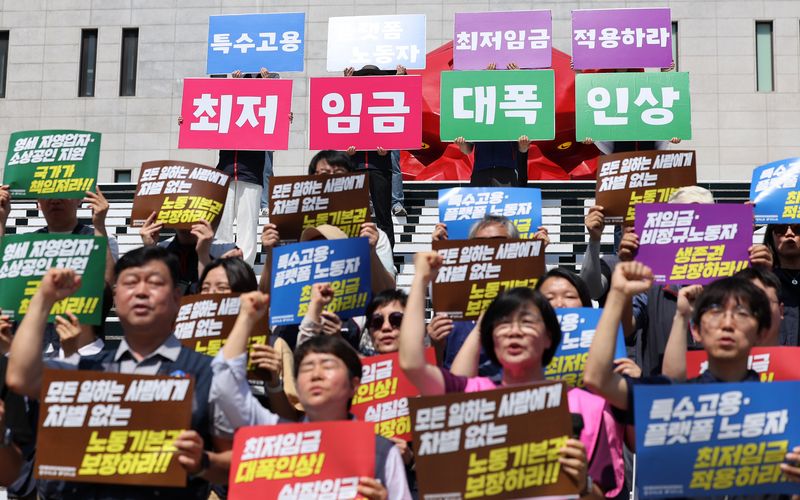 한국노총과 민주노총 관계자들이 15일 서울 종로구 세종문화회관 앞 계단에서 열린 2027년 적용 최저임금 노동계 요구안 발표 기자회견에서 구호를 외치고 있다. 2026.6.15 ⓒ 뉴스1 김성진 기자