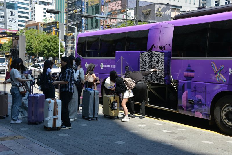 롯데백화점 부산본점에서 운영한 외국인 전용 순환버스에서 내린 관광객이 짐을 챙기고 있다. 롯데쇼핑 제공