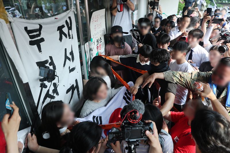 6·3 지방선거 투표용지 부족 사태로 시작한 서울 송파구 올림픽공원 핸드볼경기장 일대 ‘잠실 개표소 시위’가 열린 지난 16일 한 시민이 대한체육회 관계자들의 핸드볼경기장 진입을 막고 있다. 뉴스1
