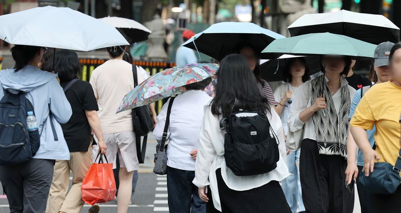 서울 광화문광장 인근 횡단보도에서 양산을 쓴 시민들이 길을 건너고 있다. 연합뉴스