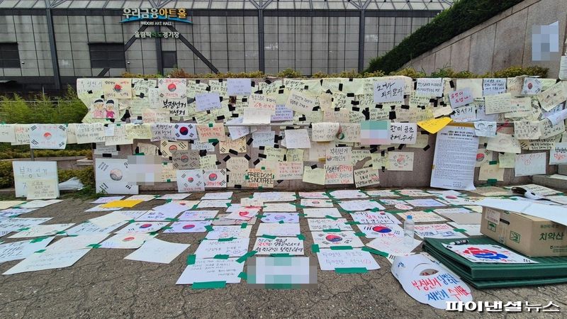 서울 송파구 올림픽공원 우리금융아트홀 인근 벽면과 바닥에 집회 참가자들이 남긴 손팻말들이 붙어 있다. 사진=한승곤 기자