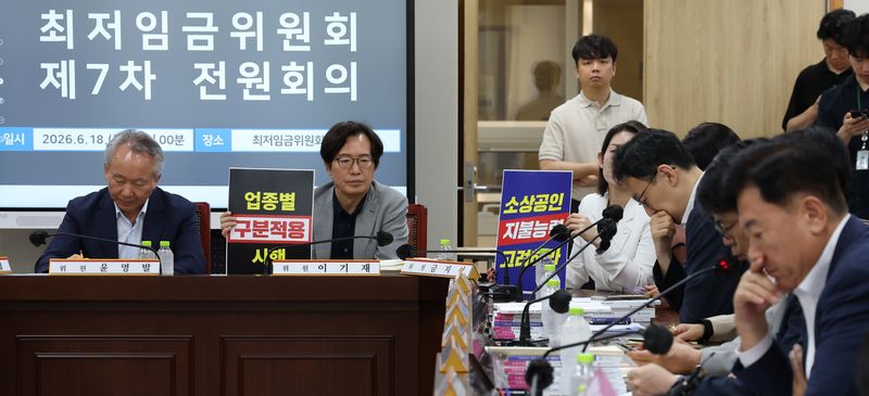 18일 세종시 정부세종청사 최저임금위원회에서 열린 2027년도 최저임금위원회 7차 전원회의에 참석한 사용자위원들이 손팻말을 들고 발언을 듣고 있다. 2026.6.18 ⓒ 뉴스1 김기남 기자