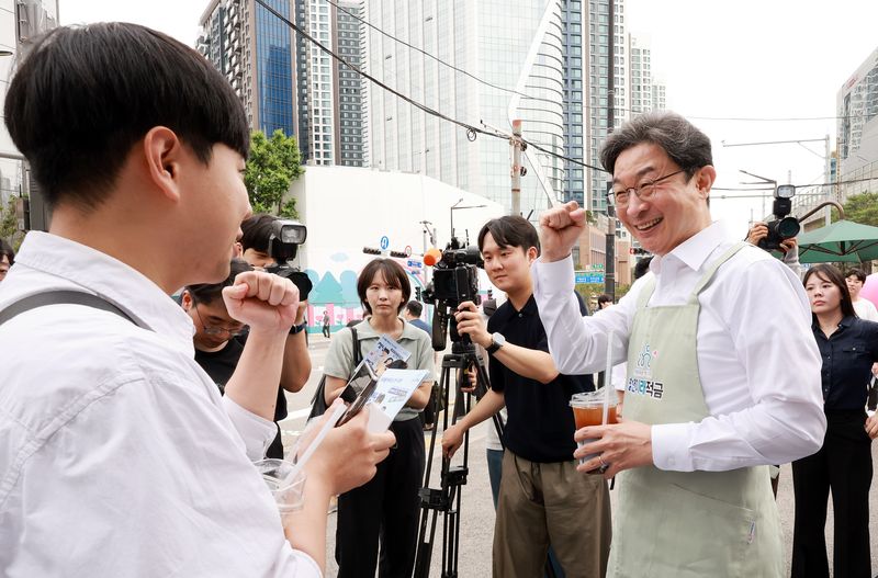 이억원 금융위원장이 '청년미래적금' 가입 신청이 시작된 22일 서울 성동구 신한빌딩 인근에서 출근길 청년들에게 커피를 나눠주며 청년미래적금을 홍보하고 있다. 2026.6.22 ⓒ 뉴스1 이호윤 기자