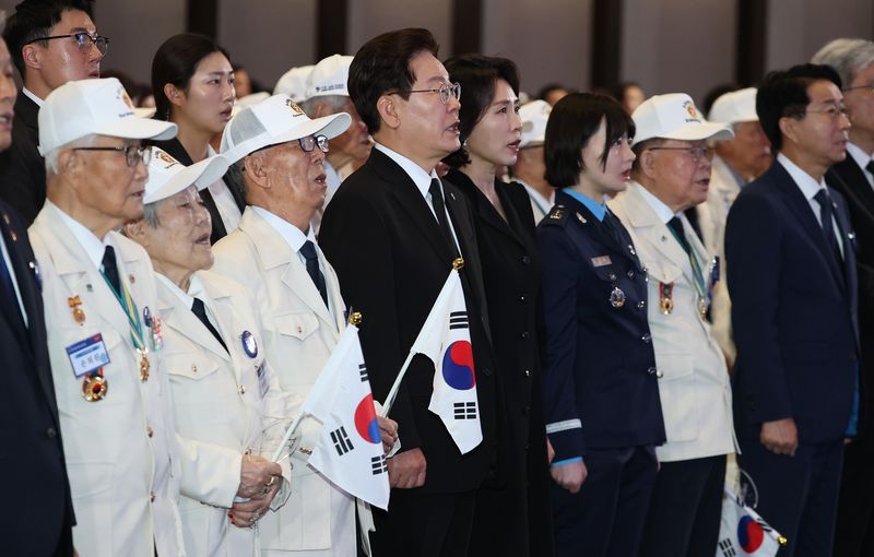 이재명 대통령과 김혜경 여사가 25일 경기 수원컨벤션센터에서 열린 6·25 전쟁 제76주년 기념식에서 애국가를 제창하고 있다. 청와대통신사진기자단