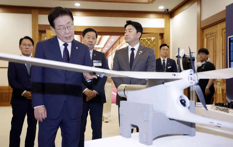 이재명 대통령이 6월 청와대에서 열린 미래 신안보 혁신기업 육성 전략회의에서 위성 옵저버 전시품을 살펴보고 있다. 뉴시스