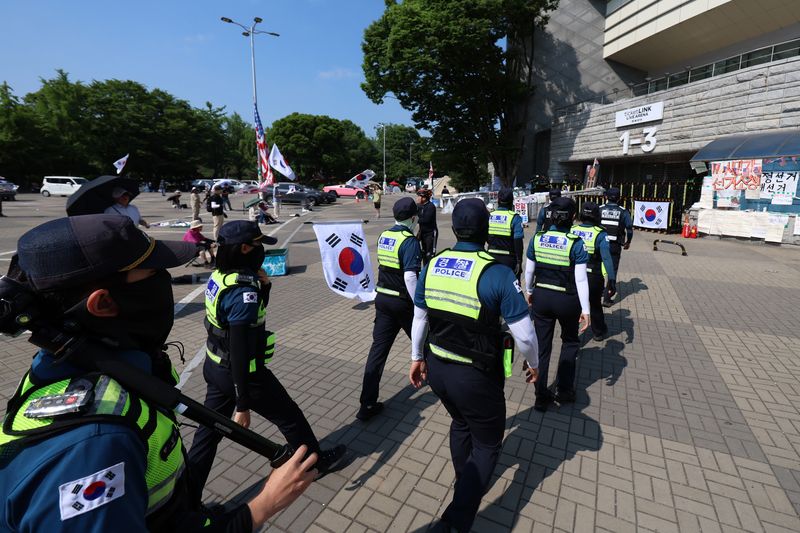 [서울=뉴시스] 조성우 기자 = 지난 18일 오전 6·3 지방선거 투표용지 부족 사태를 규탄하는 시위가 14일째 열리고 있는 서울 송파구 올림픽공원 핸드볼경기장 앞에서 경찰이 이동하고 있다. 2026.06.27. xconfind@newsis.com
