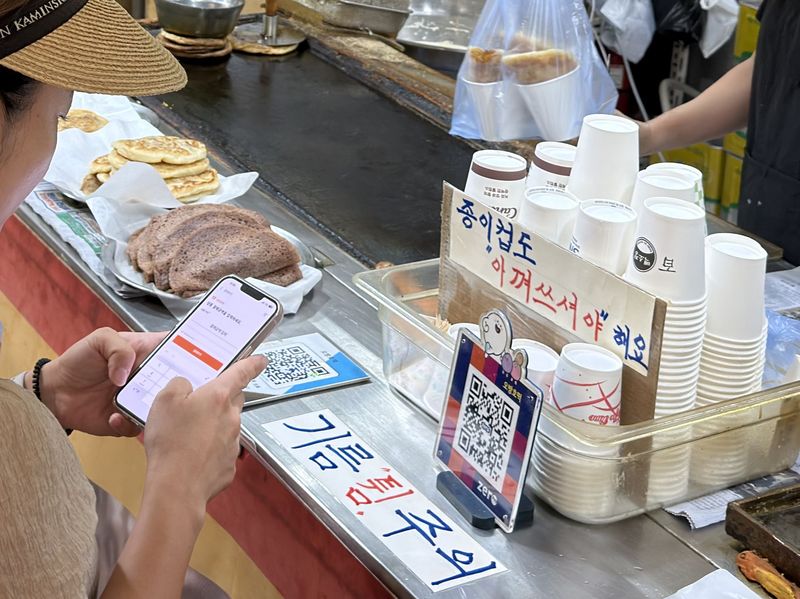 속초중앙시장에서 한 소비자가 디지털 온누리상품권을 이용해 호떡을 구매하고 있다. 사진=정원일 기자