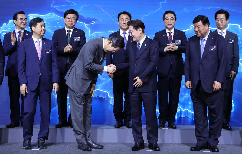 이재명 대통령이 2일 충남 아산시에서 열린 충청권 첨단산업 발전비전 국민보고회에서 참석자들과 기념촬영을 후 이재용 삼성전자 회장과 악수하고 있다. 연합뉴스