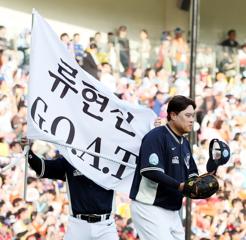 [서울=뉴시스] 박주성 기자 = 11일 오후 서울 잠실야구장에서 열린 2026 신한 SOL KBO 리그 올스타전에서 2회말 나눔 올스타 투수 류현진이 마운드에 올라서자 팀 동료 문현빈이 '류현진 GOAT'라고 적힌 현수막을 들고 따라오고 있다. 2026.07.11. park7691@newsis.com