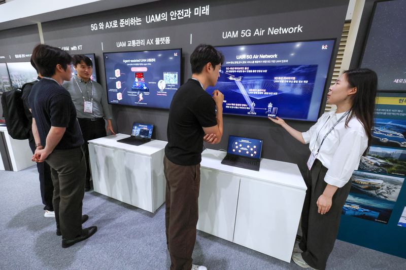 KT가 K-UAM 원팀 소속으로 현대자동차, 현대건설, 인천국제공항공사, 대한항공과 함께 구성한 공동 부스에서 관계자들이 KT의 UAM 기술을 살펴보고 있다. KT 제공