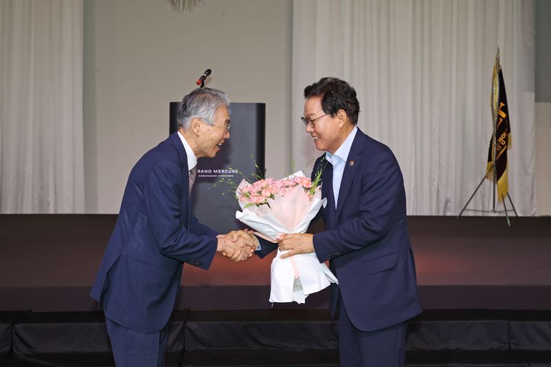 [창원=뉴시스]15일 오전 경남 창원 그랜드머큐어앰배서더 호텔에서 열린 경남경영자총협회 제341회 노사합동 조찬세미나에 참석한 박완수(오른쪽) 경남도지사가 이상연 경남경총 회장으로부터 재선 당선 축하 꽃다발을 받고 있다.(사진=경남도 제공) 2026.07.15. photo@newsis.com
