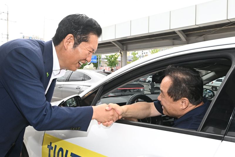 [전남광주=뉴시스] 이영주 기자 = 정청래 더불어민주당 전 당대표가 제헌절 연휴 이튿날인 18일 오전 전남광주 광산구 광주송정역에서 택시기사들과 인사를 주고받고 있다. 2026.07.18. leeyj2578@newsis.com