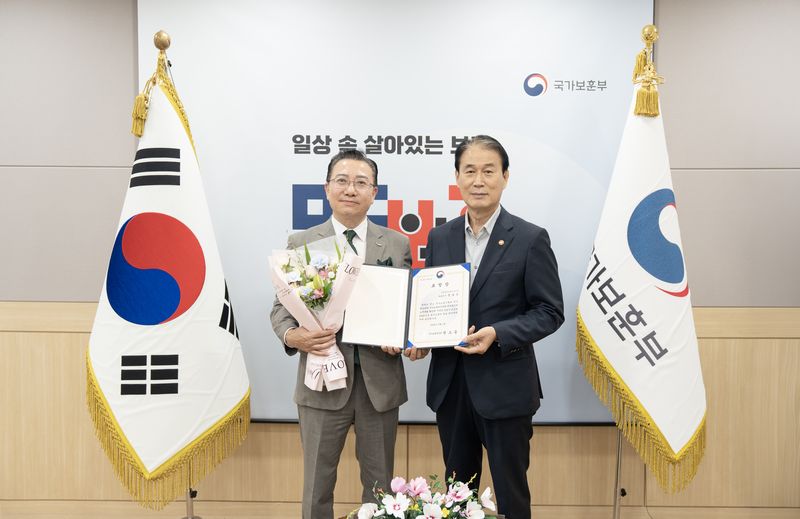 [서울=뉴시스] 문호상 웅진프리드라이프 대표이사(왼쪽)가 국가보훈 문화 확산과 호국영령 예우 활동에 기여한 공로로 권오을 국가보훈부 장관(오른쪽)으로부터 장관 표창을 받은 뒤 기념촬영을 하고 있다. (사진=웅진프리드라이프 제공) 2026.7.20. photo@newsis.com *재판매 및 DB 금지