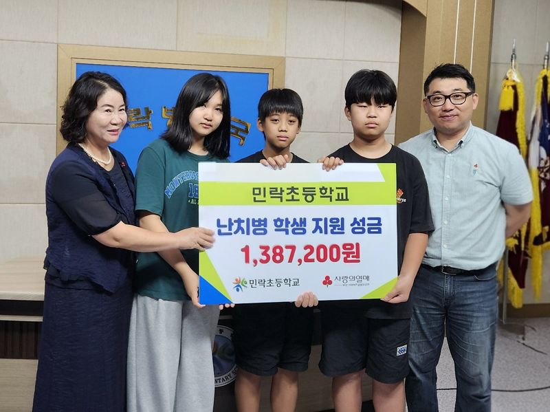 부산 민락초등학교 김경숙 교장(왼쪽)과 학생들이 부산사랑의열매에 성금을 전달한 후 기념촬영을 하고 있다.