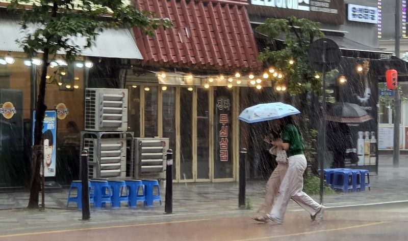 22일 오후 세종 나성동 인근에 거센 장맛비가 내려 시민들이 비를 피하고 있다. 2026.7.22 ⓒ 뉴스1 황덕현 기후환경전문기자