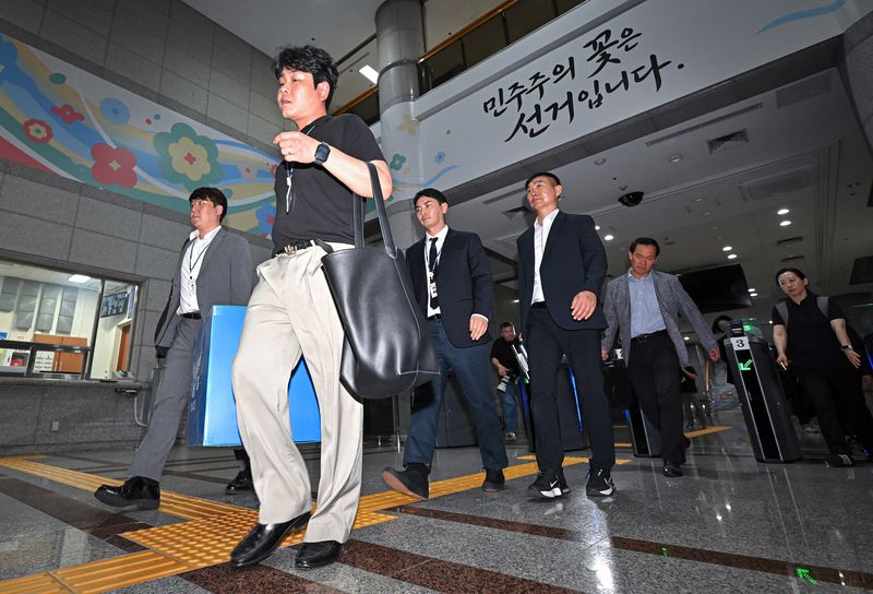 6·3 지방선거 투표용지 부족 사태를 수사하는 검경 합동수사본부 수사관들이 11일 경기도 과천시 중앙선거관리위원회에 대한 압수수색을 마친 뒤 압수품을 들고 건물을 나오고 있다. (공동취재) 2026.6.11 ⓒ 뉴스1 이호윤 기자