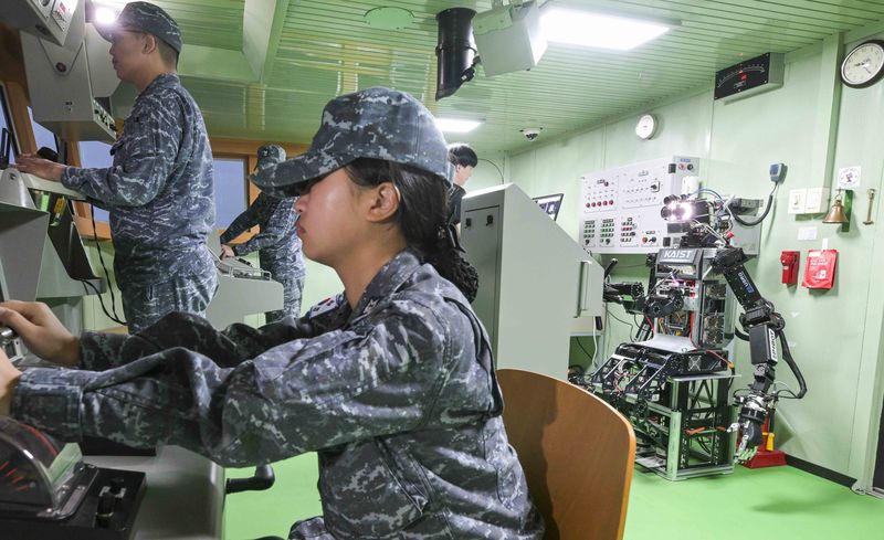 23일 해군교육사령부 조함훈련장에서 해군 최초로 진행된 로봇 승조원 전투실험에서 휴머노이드 로봇 '파이봇(PIBOT)'이 이지스구축함 서애류성룡함(DDG) 소속 함교 당직사관의 조함명령에 따라 타수 업무를 수행하고 있다. 해군 제공