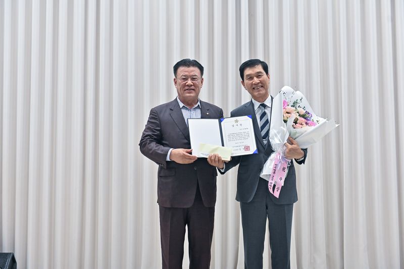 박사익 민주평화통일자문회의 부산지역회의 부의장(경부공영 회장·왼쪽)이 북구회의회 관계자에게 감사장을 수여하며 포즈를 취하고 있다. 민주평화통일자문회의 부산지역회의 제공
